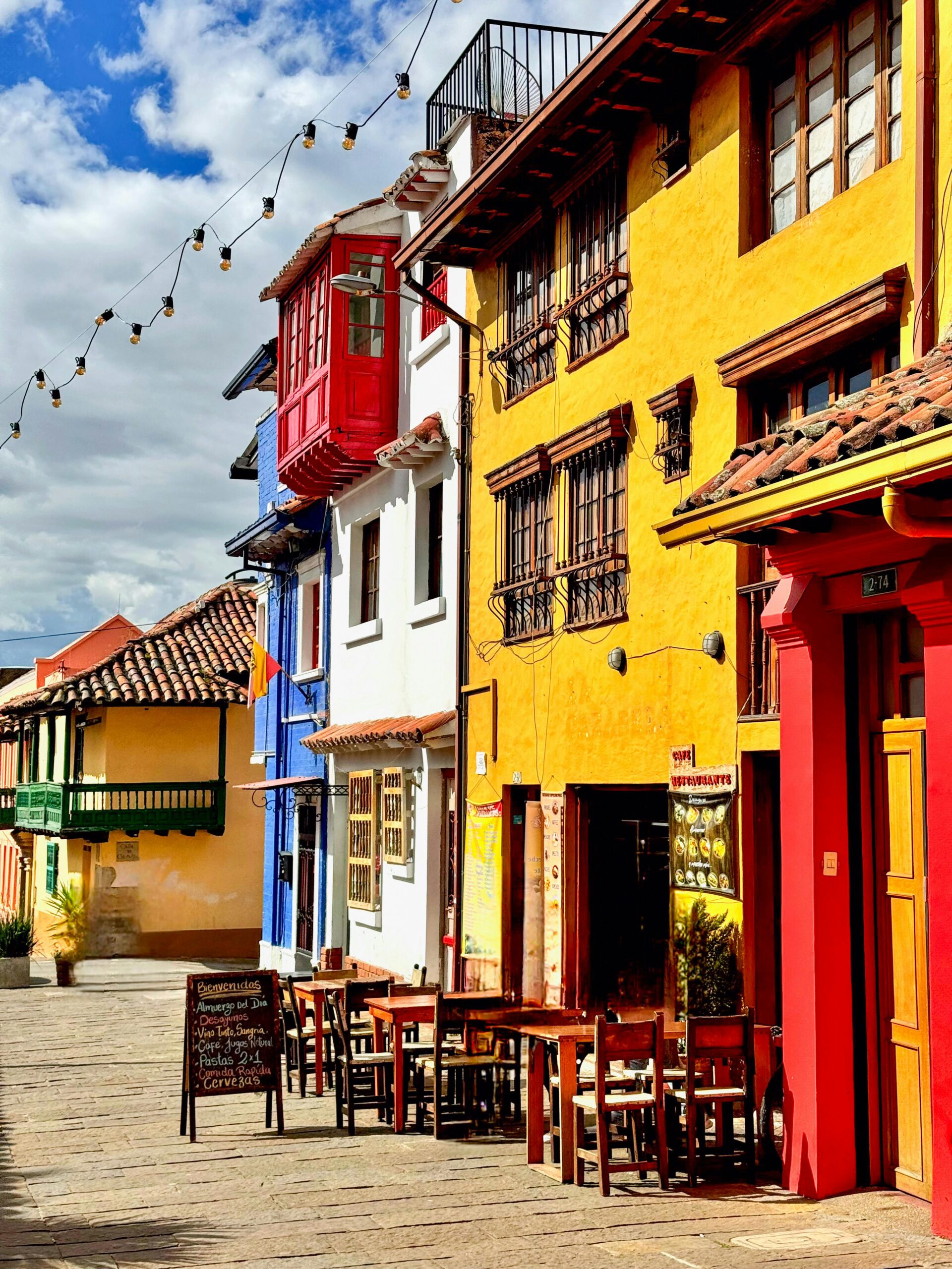 Vibrant colonial architecture in Bogotá's historic district with colorful facades and outdoor seating.